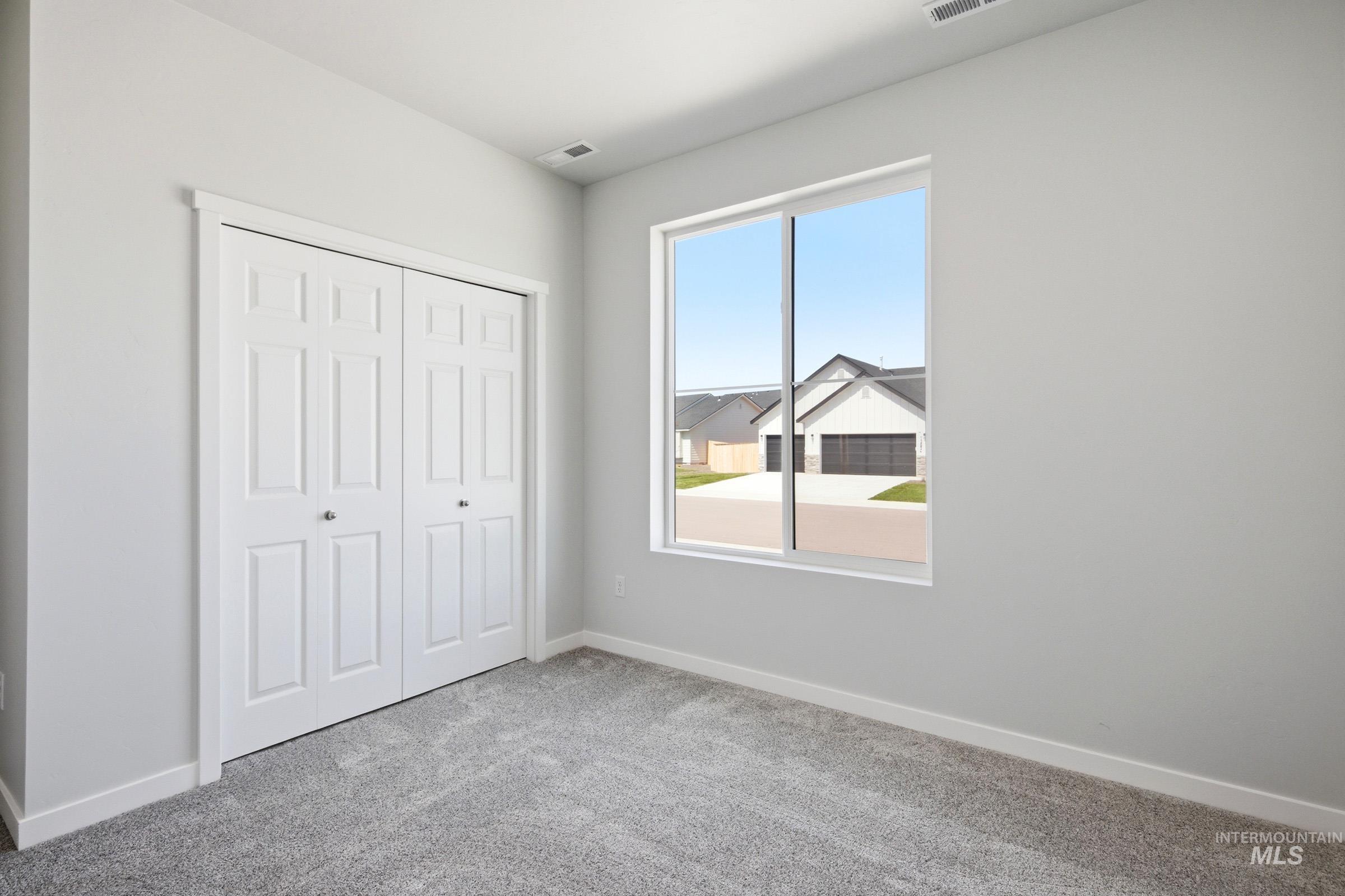 13649 Inman Court Caldwell, ID 83607 - Photo 16 of 22 Light gray walls with white baseboards and trim, complemented by gray carpeting