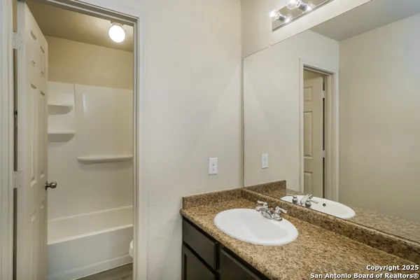 a bathroom with a granite countertop sink and a mirror