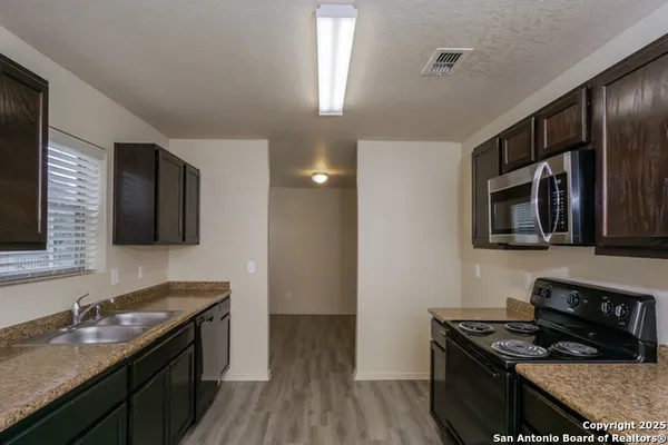 a kitchen with granite countertop stainless steel appliances and wooden cabinets