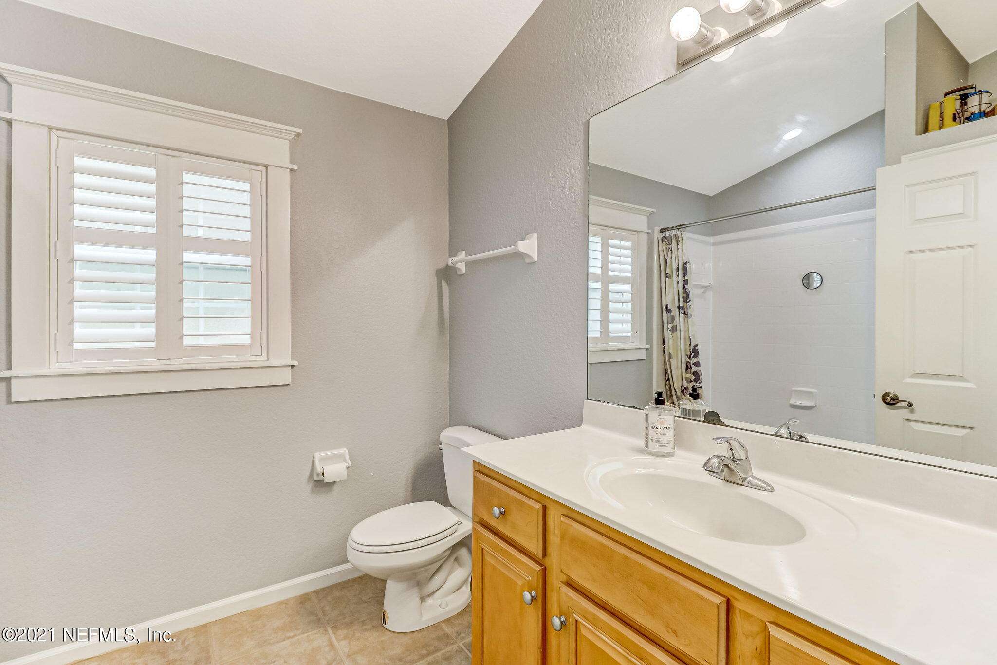 96931 Blackrock Road Yulee, FL 32097 - Photo 20 of 28 a bathroom with a granite countertop toilet a sink a mirror and a window
