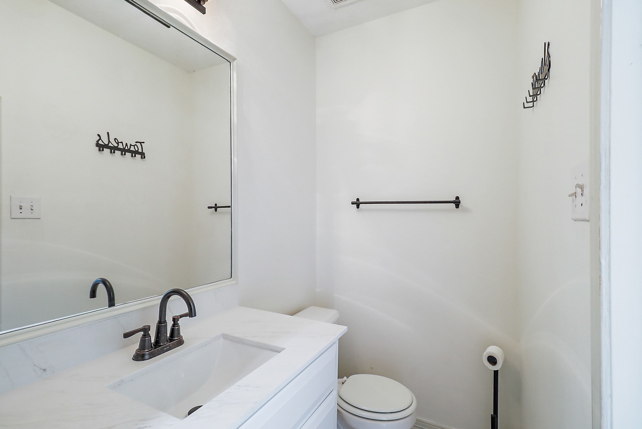 1306 Spring Branch Drive Baytown, TX 77523 - Photo 12 of 38 a bathroom with a sink a toilet and mirror