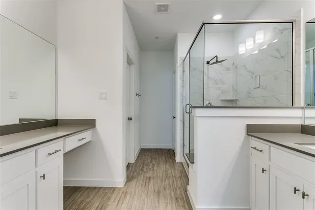 a bathroom with a granite countertop sink a mirror and shower