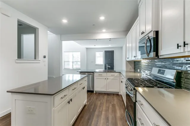 a kitchen with granite countertop a sink stove and cabinets