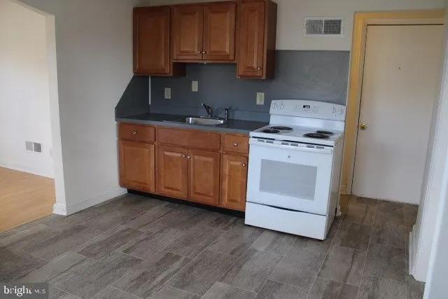a kitchen with granite countertop wooden cabinets and white appliances