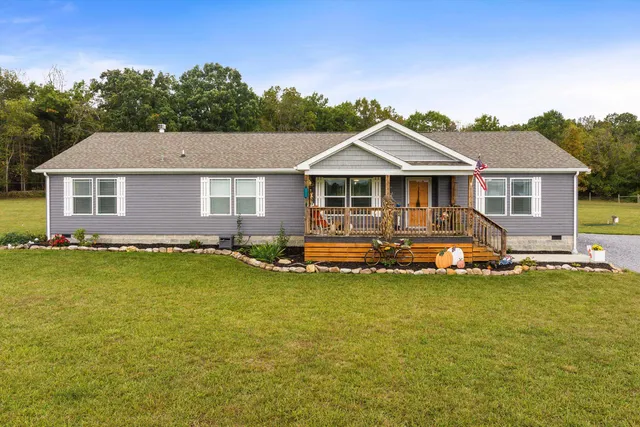 a front view of a house with a garden and yard