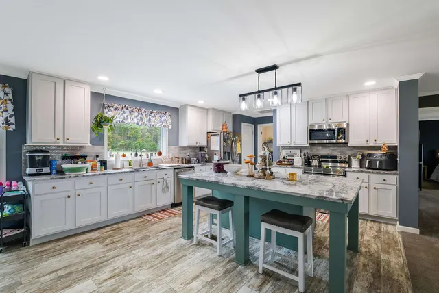 a kitchen with stainless steel appliances granite countertop a refrigerator stove a sink and dishwasher