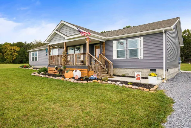 a view of a chairs setting on the deck in front of house