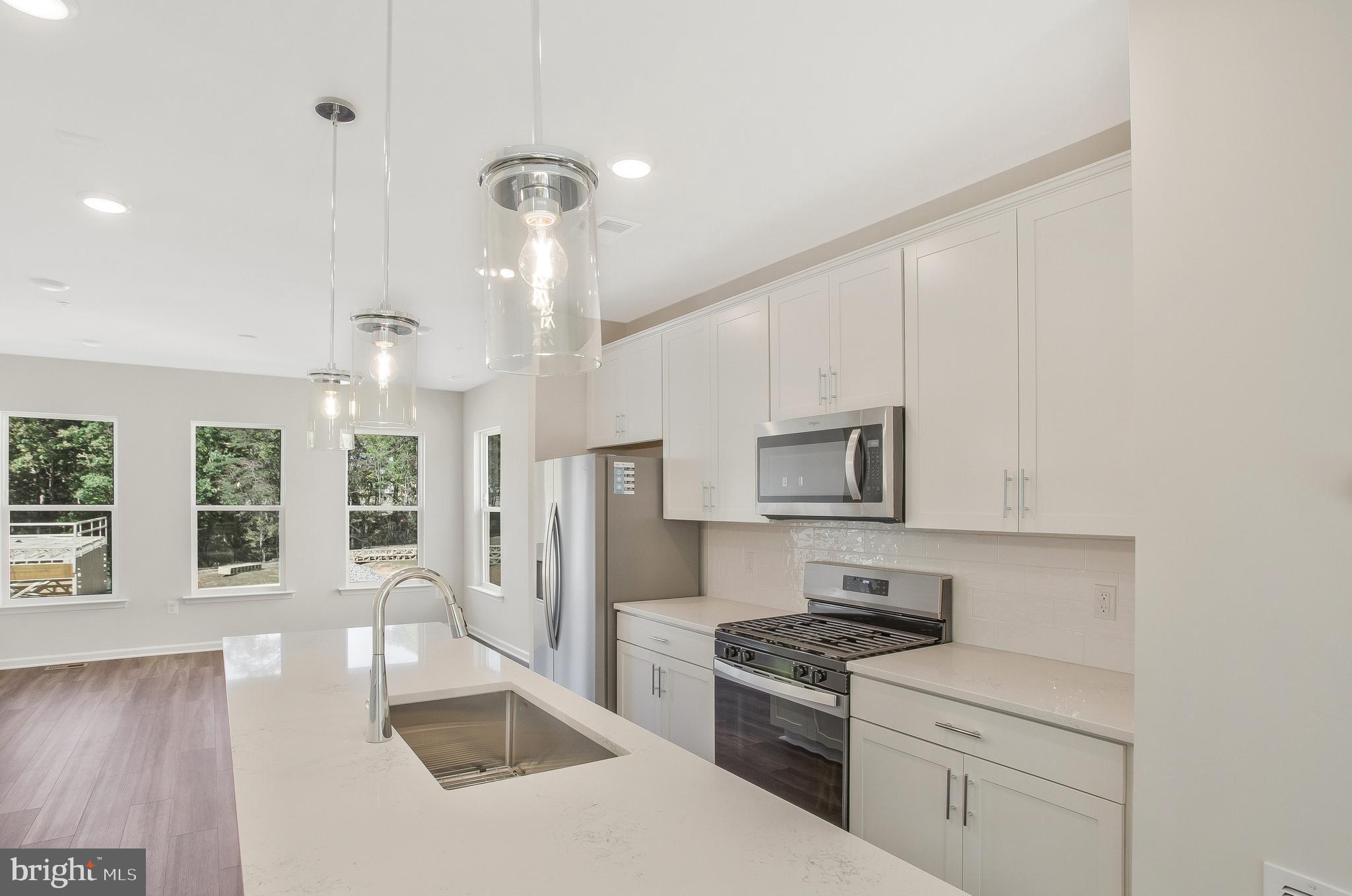 244 Mainstream Drive Laurel, MD 20724 - Photo 11 of 36 a kitchen with stainless steel appliances granite countertop a stove a sink dishwasher a refrigerator white cabinets and wooden floor