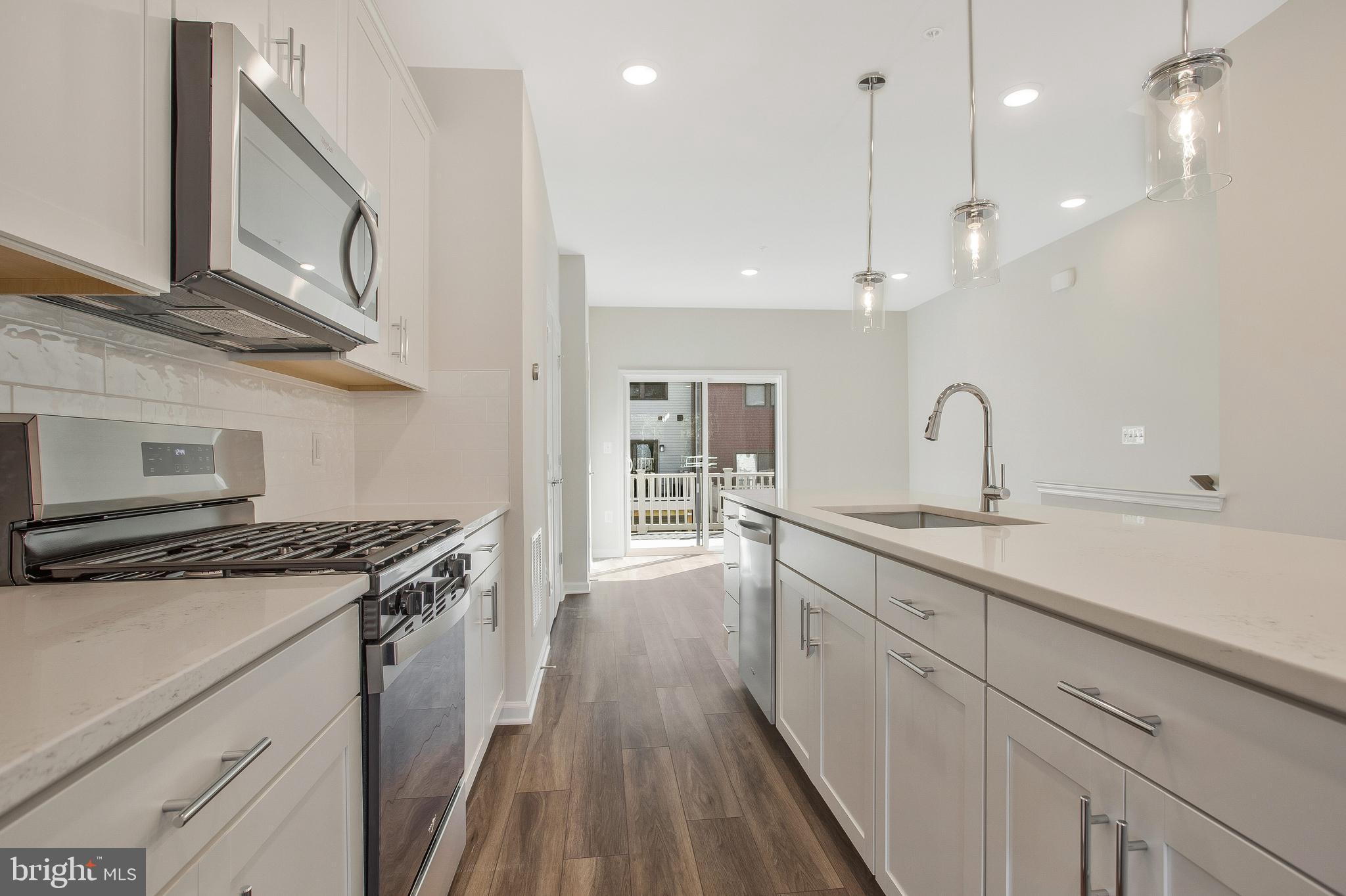 244 Mainstream Drive Laurel, MD 20724 - Photo 13 of 36 a kitchen with stainless steel appliances granite countertop a sink stove and cabinets