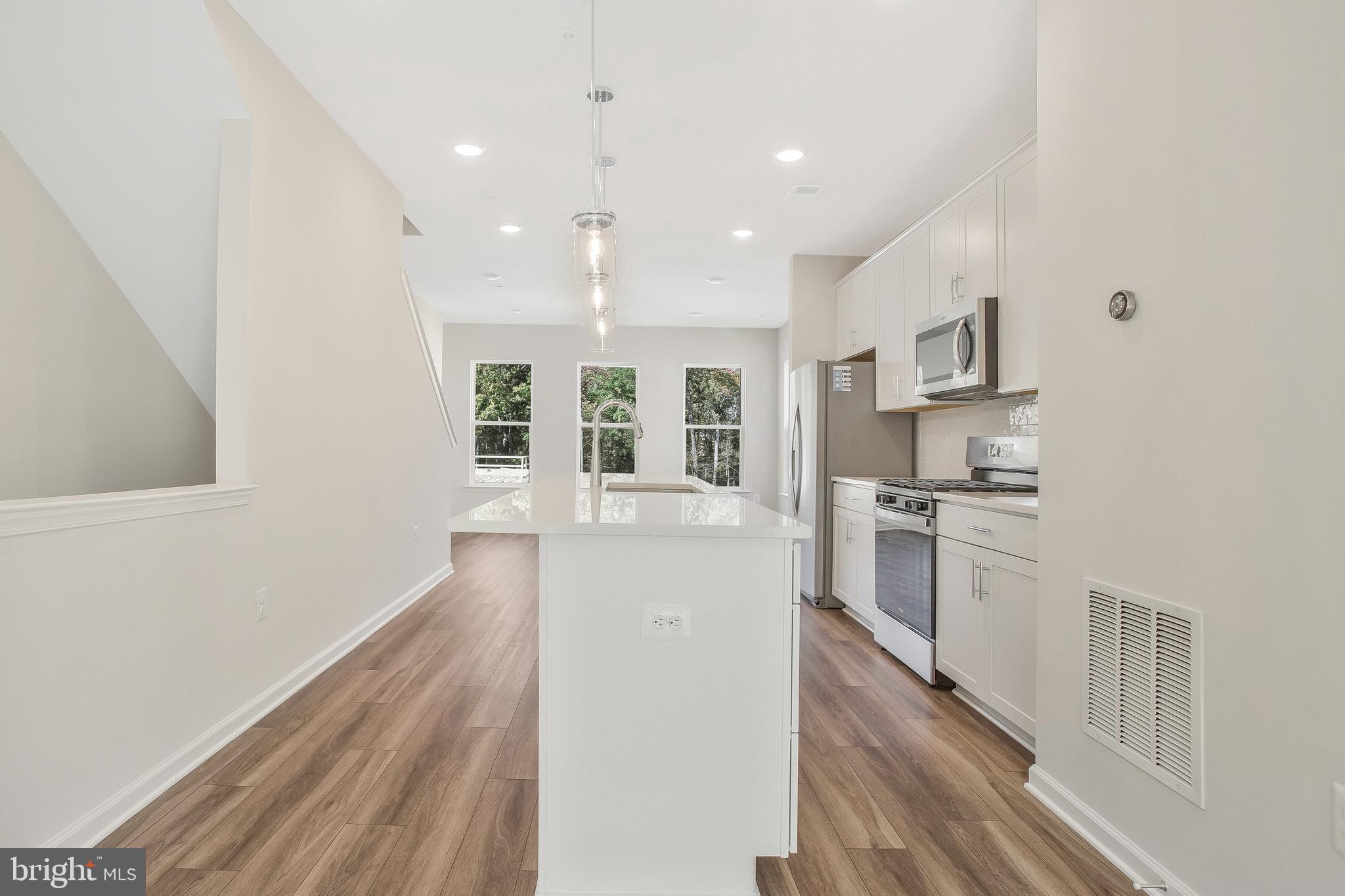 244 Mainstream Drive Laurel, MD 20724 - Photo 9 of 36 a kitchen with white cabinets and appliances