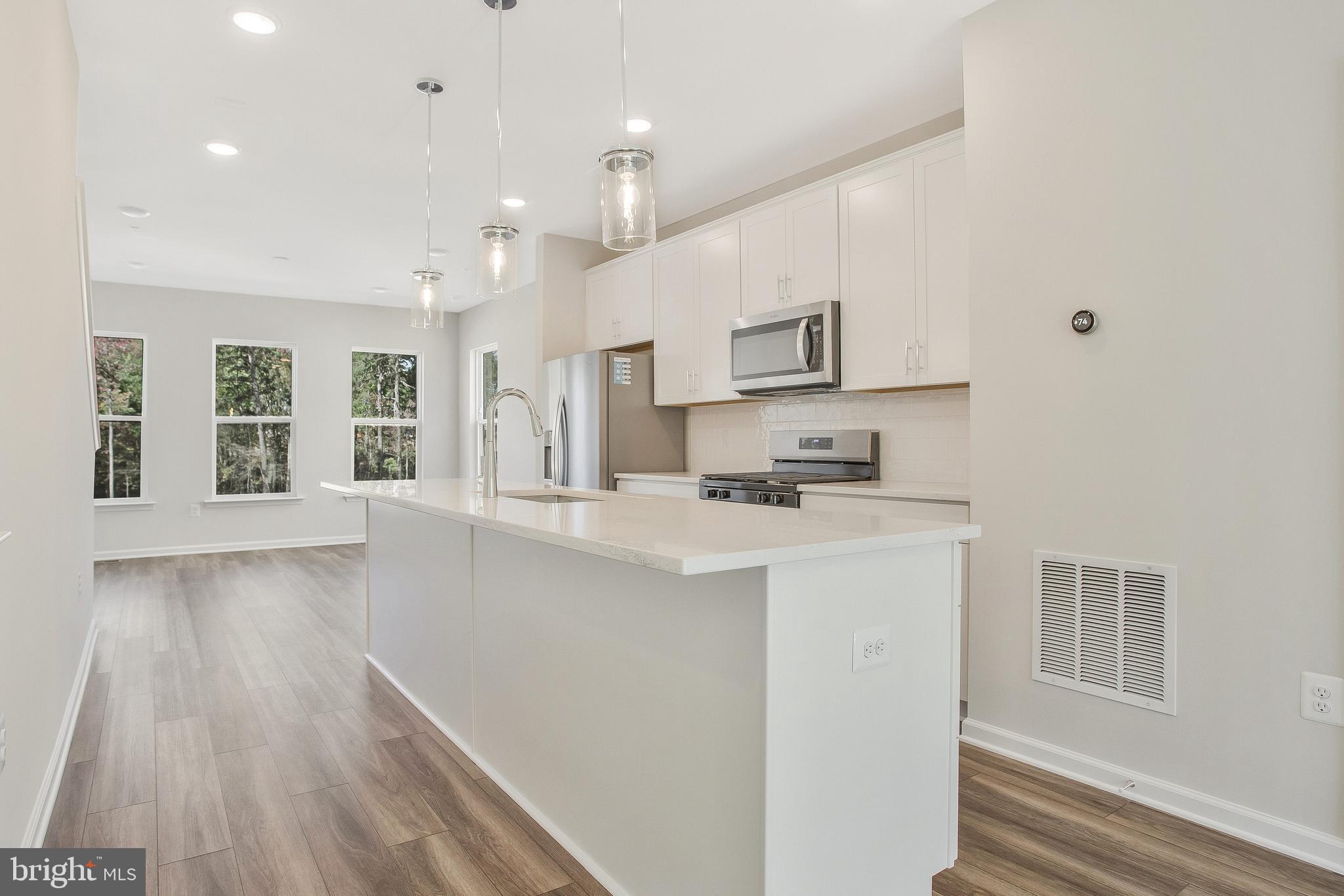 244 Mainstream Drive Laurel, MD 20724 - Photo 10 of 36 a kitchen with stainless steel appliances granite countertop a stove a sink and a refrigerator