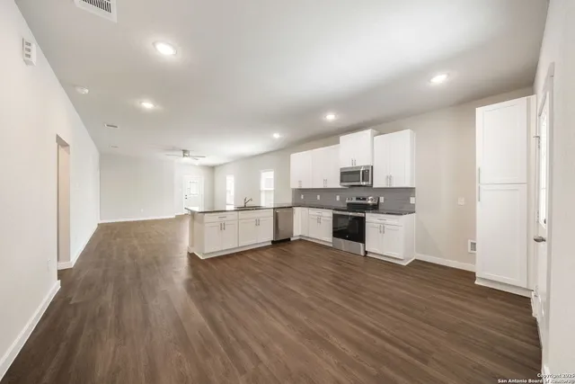 an empty room with windows and fan