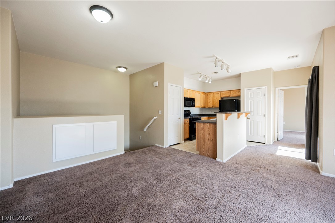 6320 Snap Ridge Street, Unit 201 North Las Vegas, NV 89081 - Photo 55 of 56 An open floor plan seamlessly connects the cozy living area to a compact, well-appointed kitchen.