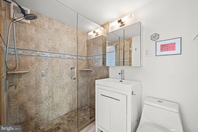 a bathroom with a sink a toilet and shower