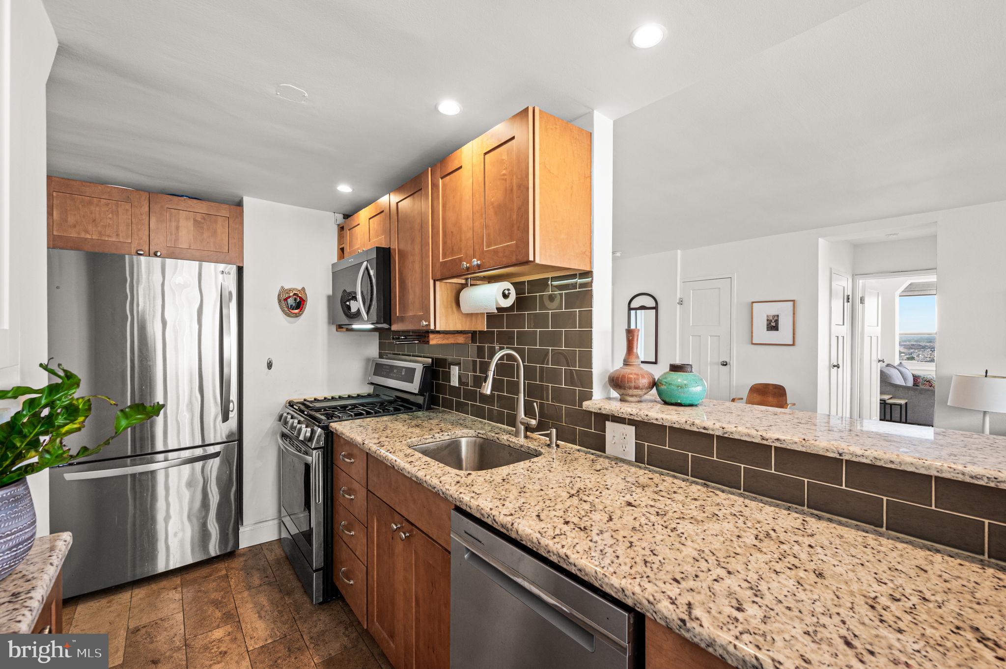 1806-18 Rittenhouse Square, Unit 190607 Philadelphia, PA 19103 - Photo 8 of 34 a kitchen with stainless steel appliances granite countertop a sink a stove and a refrigerator