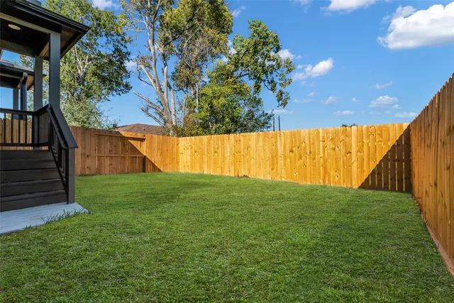 a view of yard with swimming pool and wooden fence