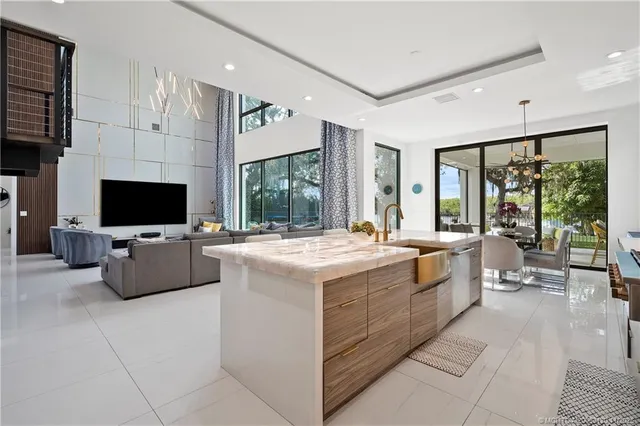 a kitchen with kitchen island a stove a table and chairs in it