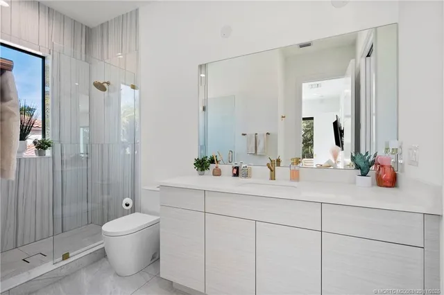 a bathroom with a sink a toilet and shower