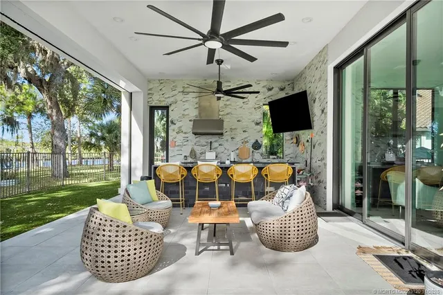 a living room with furniture a flat screen tv and a floor to ceiling window