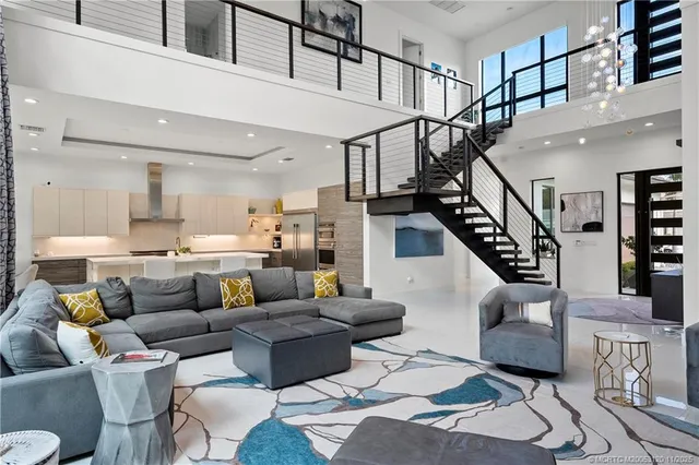 a living room with furniture staircase and a large window