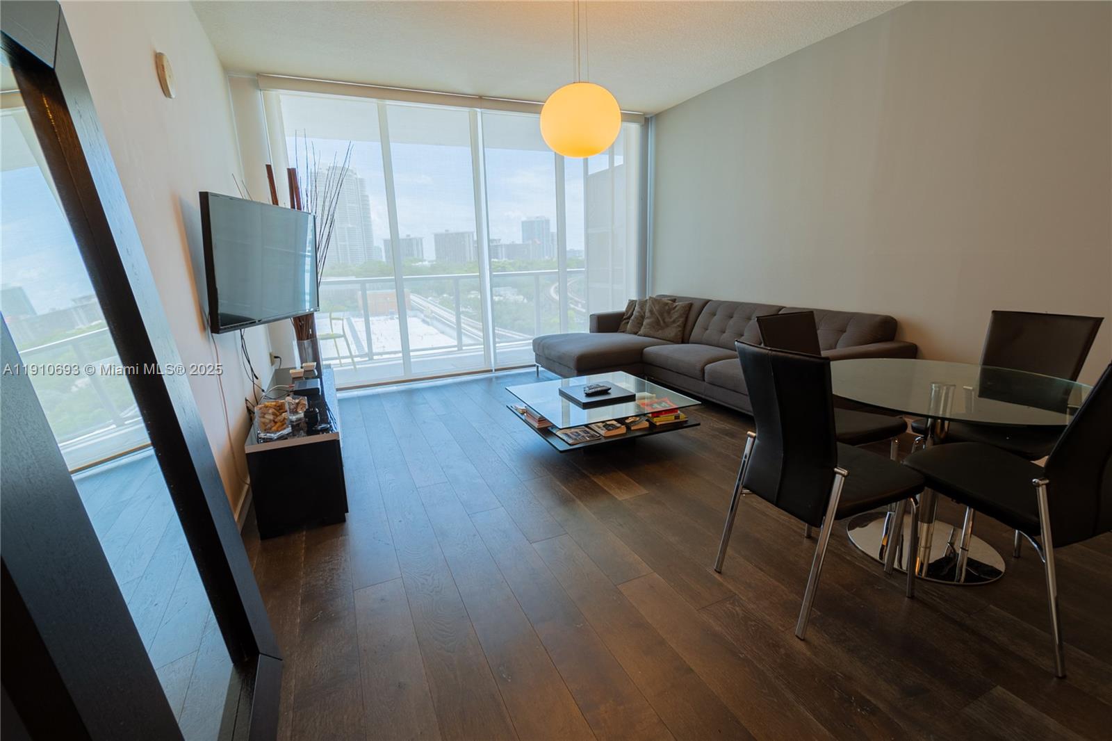 79 Southwest 12th Street, Unit 1002S Miami, FL 33130 - Photo 12 of 22 a living room with furniture and a flat screen tv
