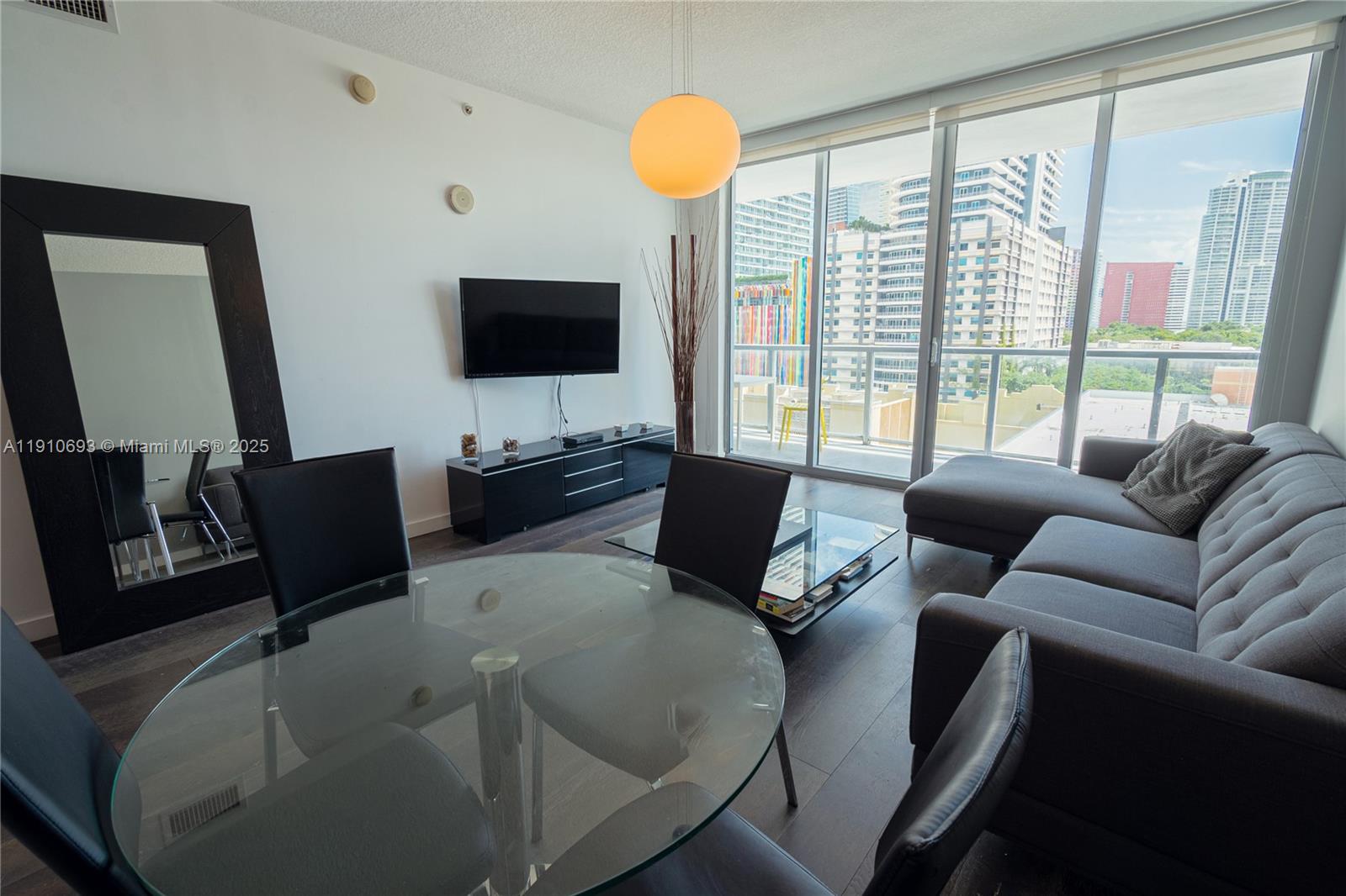 79 Southwest 12th Street, Unit 1002S Miami, FL 33130 - Photo 4 of 22 a living room with furniture and a flat screen tv