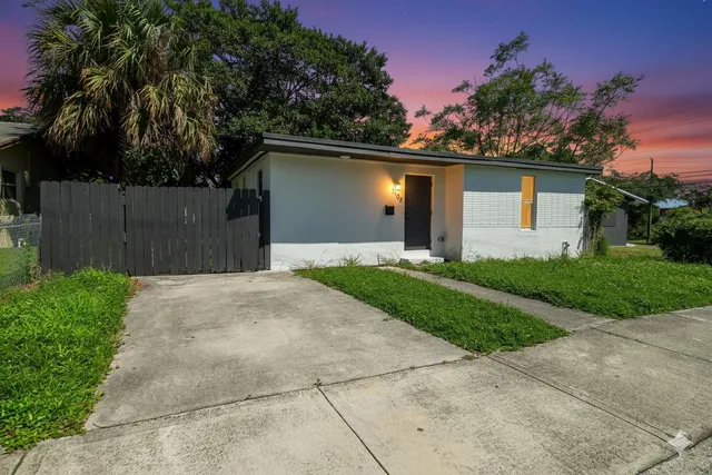 a front view of house with yard and trees in the background