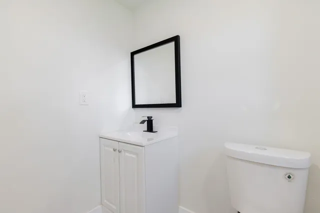 a bathroom with a toilet sink and mirror