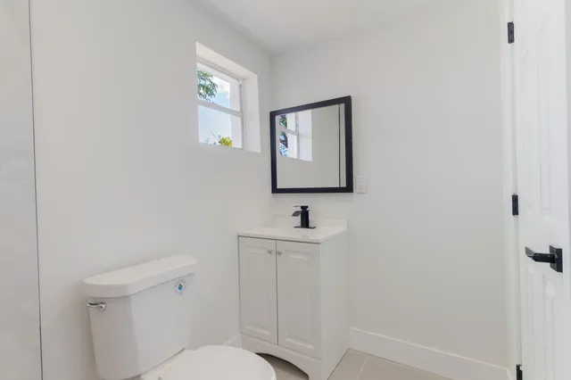 a bathroom with a toilet a sink and mirror