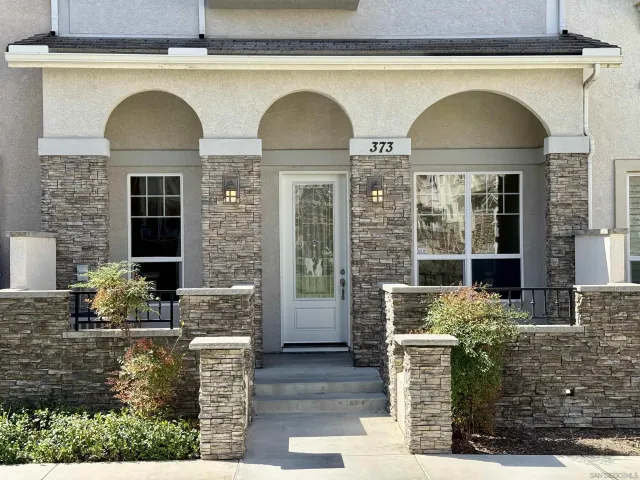 a front view of a house with plants