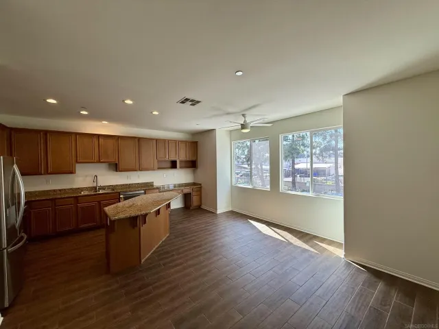 a kitchen with kitchen island granite countertop a stove top oven a sink and a microwave