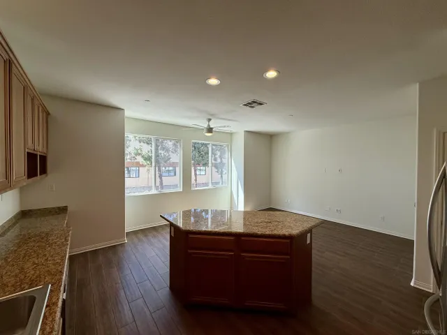 a living room with kitchen island granite countertop wooden floor