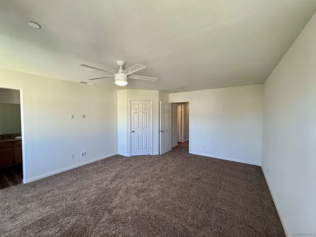 an empty room with a empty space and a ceiling fan