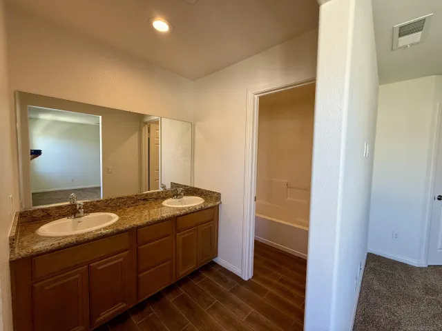 a bathroom with a granite countertop sink shower and a mirror