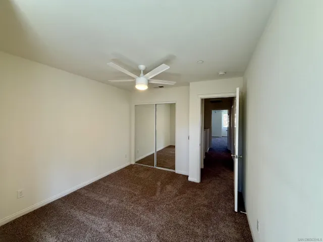 an empty room with closet and a hallway