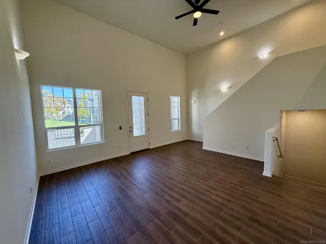 a view of an empty room with window and wooden floor