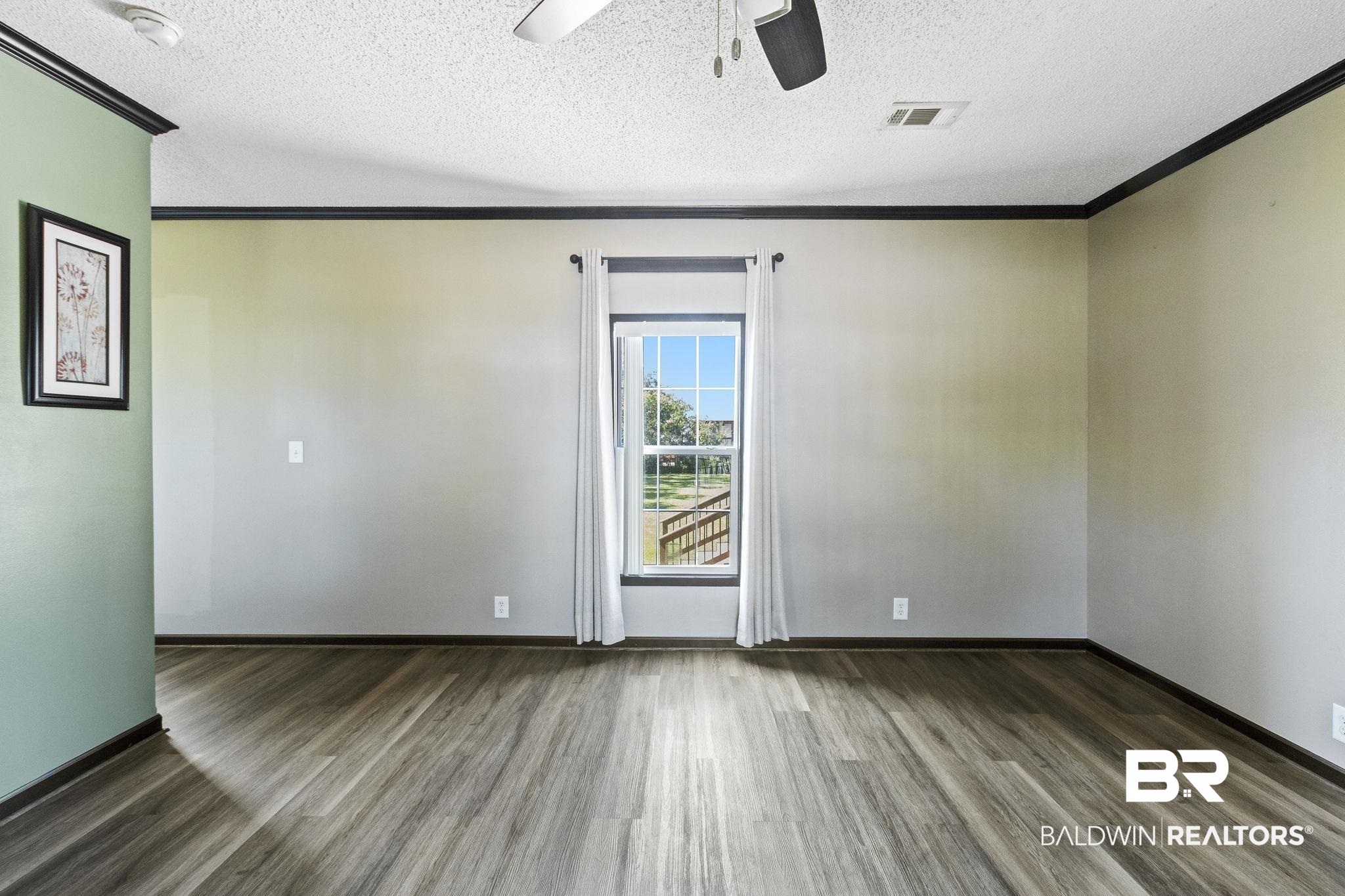 6870 Cecilia Court Theodore, AL 36582 - Photo 12 of 83 Unfurnished room with ceiling fan, dark hardwood / wood-style floors, ornamental molding, and a textured ceiling