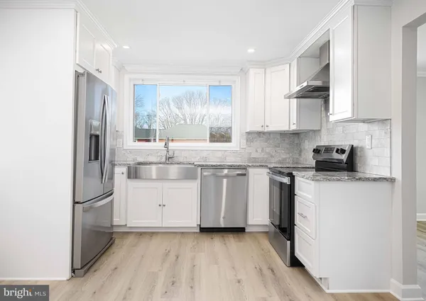 a kitchen with granite countertop white cabinets and white appliances