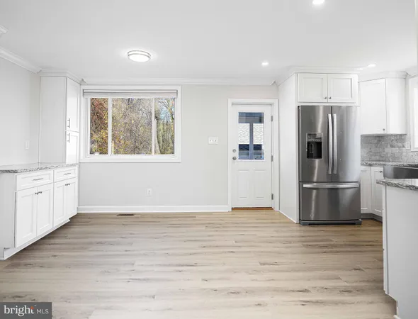 a view of a kitchen with wooden floor and electronic appliances