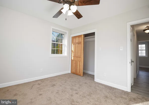 an empty room with chandelier fan