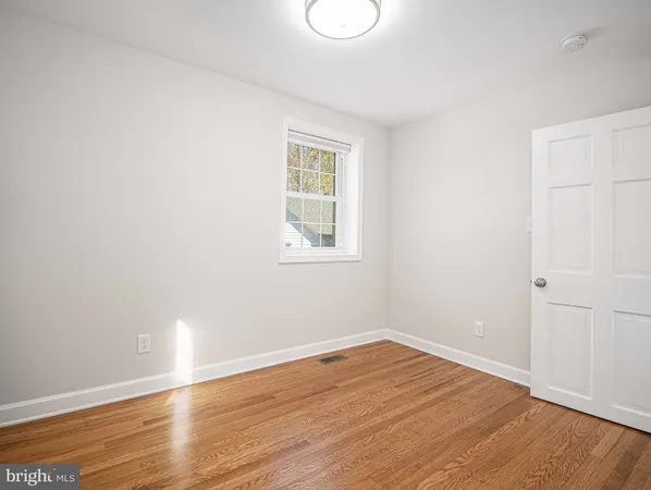 a view of empty room with wooden floor and windows