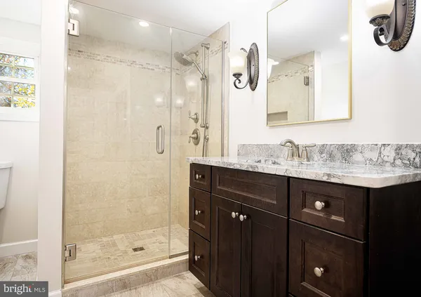 a bathroom with a granite countertop sink mirror and shower