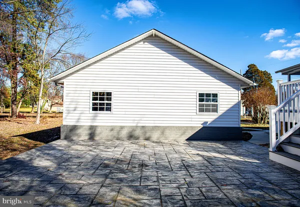 a view of a house with a wooden deck and furniture