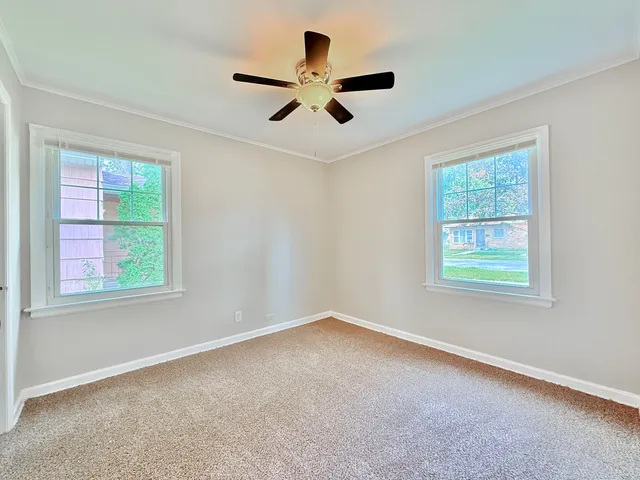 an empty room with a window and a fan