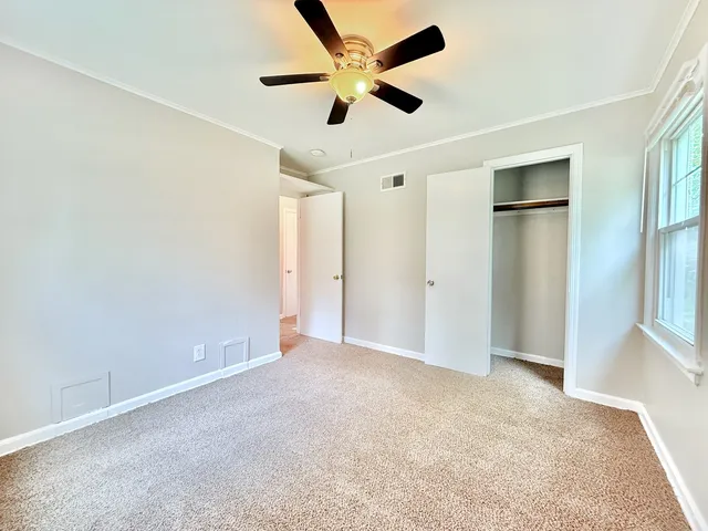 an empty room with closet and windows