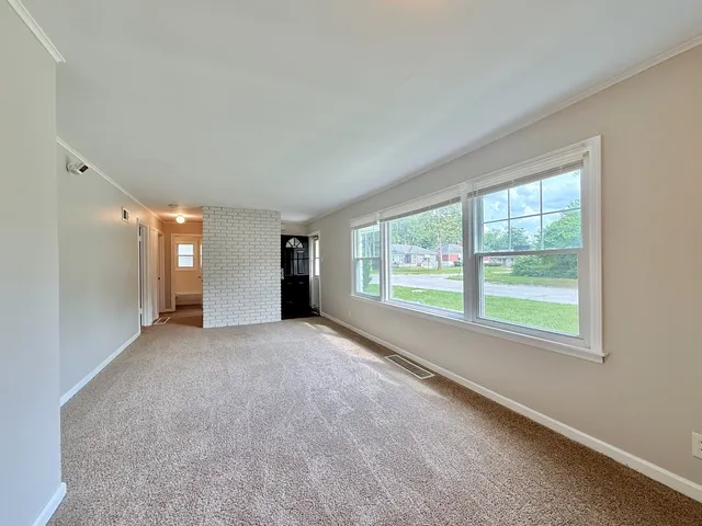 a view of a big room with windows and chandelier fan