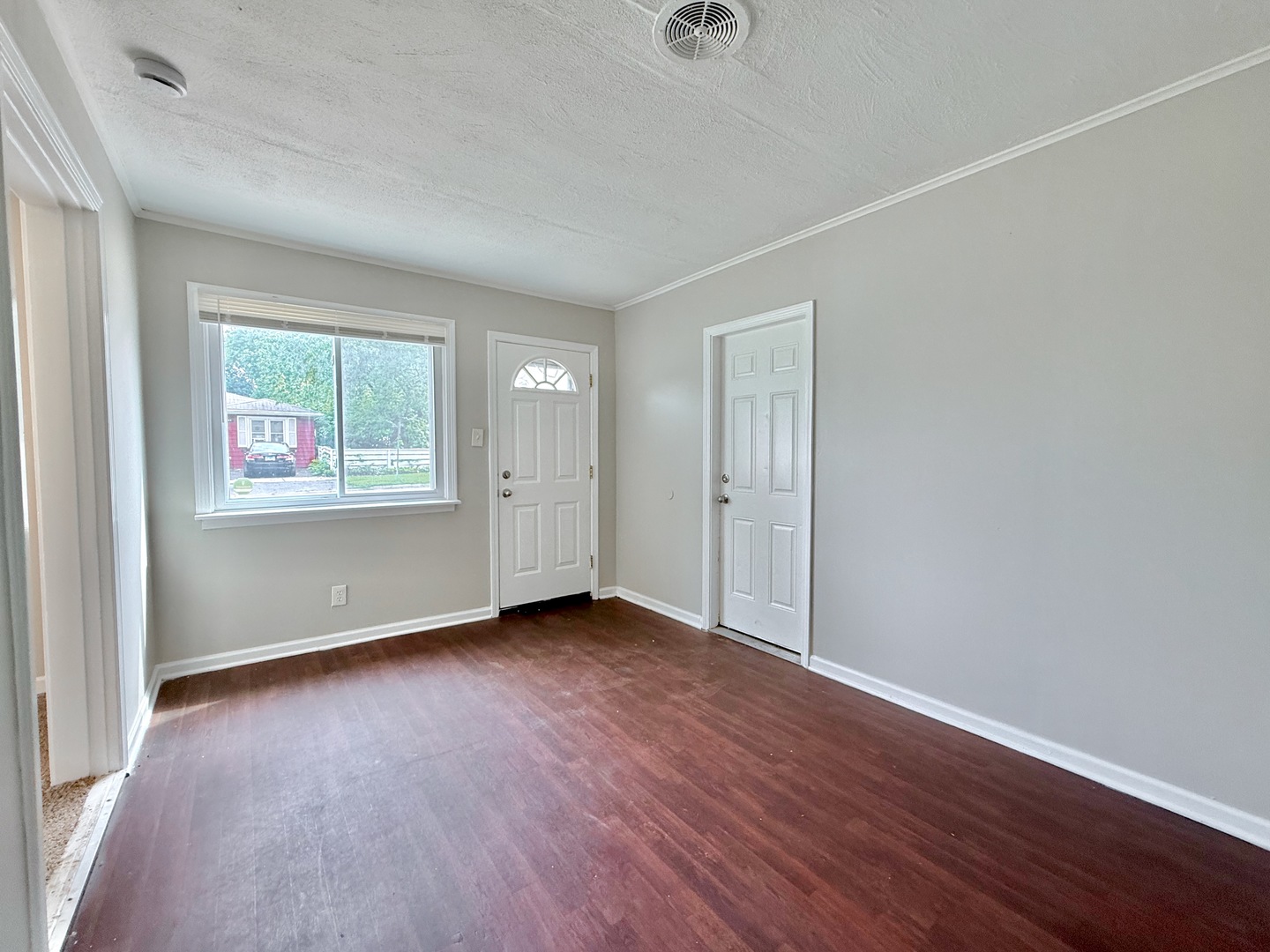 16784 Crane Avenue Hazel Crest, IL 60429 - Photo 8 of 24 an empty room with wooden floor cabinet and windows