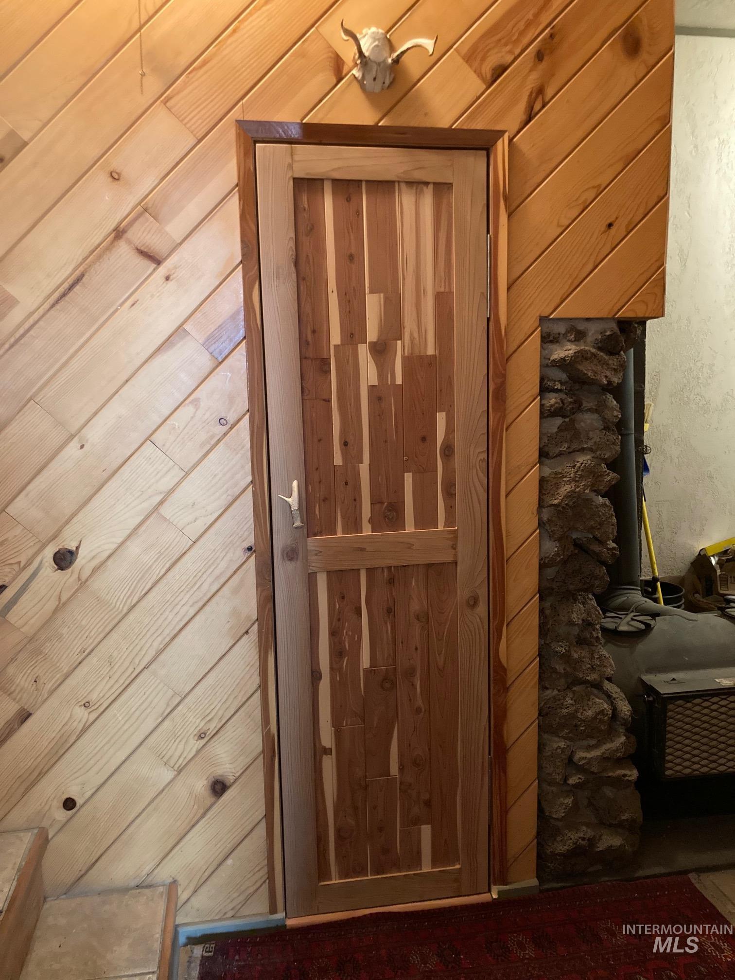 266 Falcon Ridge Road Kooskia, ID 83539 - Photo 25 of 50 Cedar sauna with diagonal planking, featuring a custom wood door with a unique plank pattern
