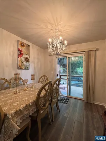 a view of a dining room with furniture a chandelier and wooden floor