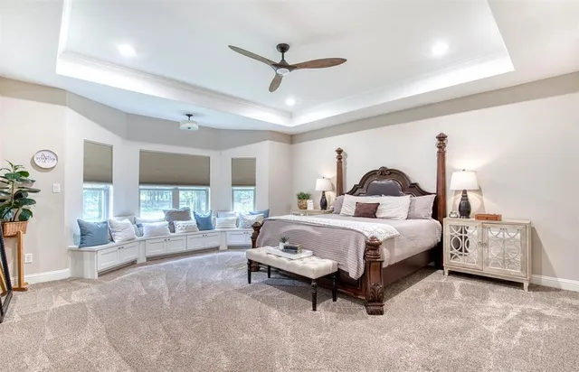 a spacious bedroom with a bed and a ceiling fan